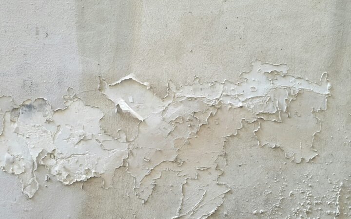 Discolored patches on a white wall near a ceiling, typical of condensation and mold